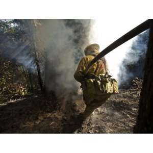  A firefighter blasts water in attempts to drown stubborn 