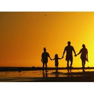  A Family Holding Hands is Silhouetted against the Setting 